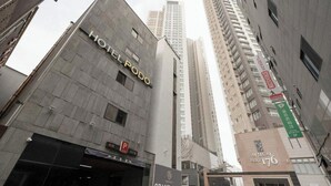 Un edificio di un albergo con un cartello che riporta 'HOTEL FOOD' e un cartello con scritto 'GRANDE APERTURA' sotto.