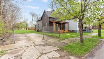 A residential property with a stone pathway leading to a house with a porch.