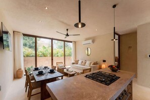 A modern kitchen with a central island, dining area, and a ceiling fan. - 2BR Jungle Retreat with Plunge Pool & Rooftop (Tulum)
