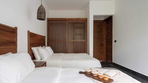 A hotel room with two beds, a wooden wardrobe, a bedside table, and a tray with books and a cup. - Luxury Jungle Villa with Private Pool & Concierge (Tulum)