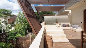 A modern outdoor staircase leading to a rooftop area with a seating arrangement and a view of the surrounding greenery. - Luxury Jungle Villa with Private Pool & Concierge (Tulum)