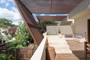 A modern outdoor staircase leading to a rooftop area with a seating arrangement and a view of the surrounding greenery. - Luxury Jungle Villa with Private Pool & Concierge (Tulum)