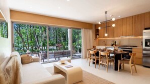 Ein moderner Wohnraum mit Sofa, Esstisch und Küchenzeile.