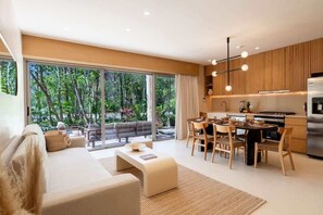 A modern living space with a sofa, dining table, and kitchen area. - Elegant 3BR in Aldea Zama with Private Pool (Tulum)