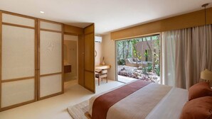 Ein Schlafzimmer mit Bett, Schreibtisch und Blick auf einen Garten.