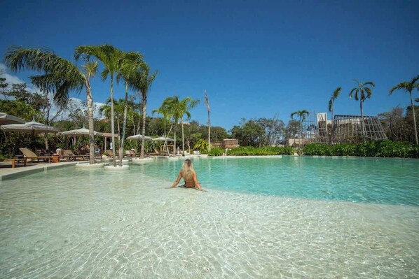A clear pool with lounge chairs and palm trees. - Elegant 3BR in Aldea Zama with Private Pool (Tulum)