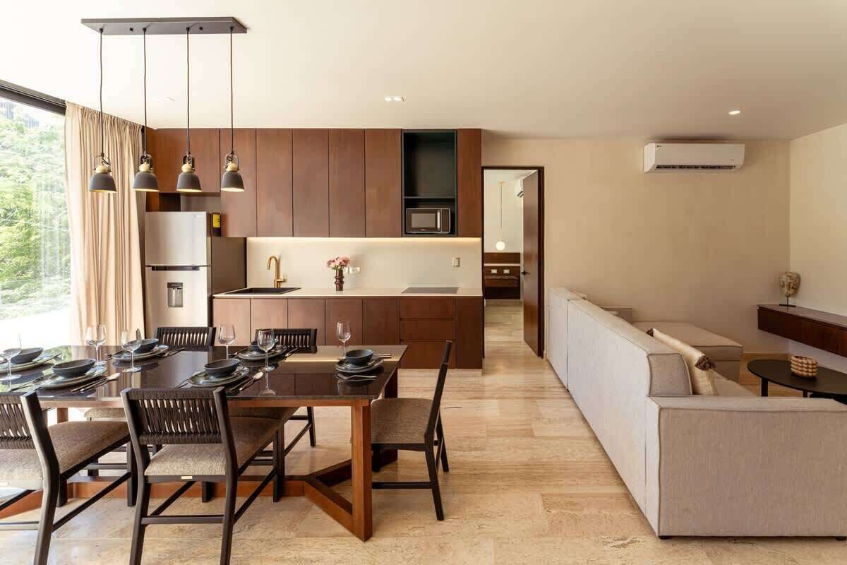 A modern kitchen with a dining area, a built-in oven, and a microwave.