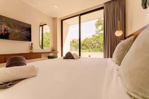 A hotel room with a large bed, a flat-screen TV mounted on the wall, a large window with a view of greenery, and a sliding glass door. - Sleek Penthouse Escape with Rooftop Pool (Tulum)