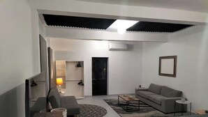 Una habitación moderna con sofá, cama, mesita de café y lámpara.