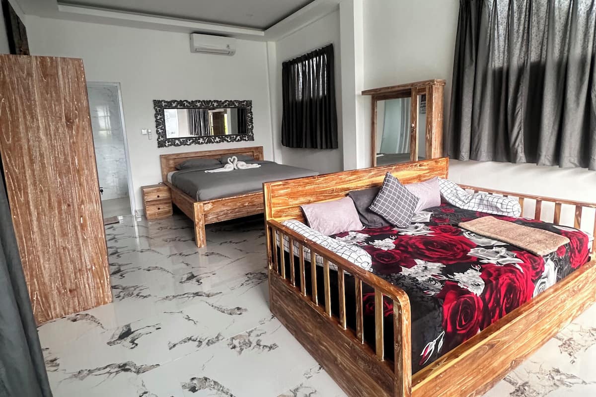 Une chambre à coucher avec un lit en bois, une armoire en bois, un sol en marbre et une grande fenêtre avec des rideaux.