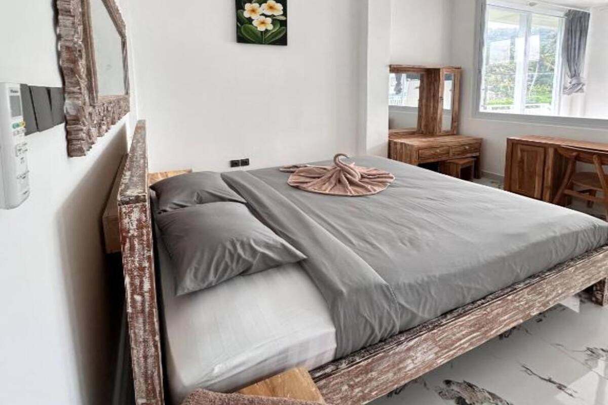 Une chambre à coucher avec un lit, un miroir, un bureau et une fenêtre.
