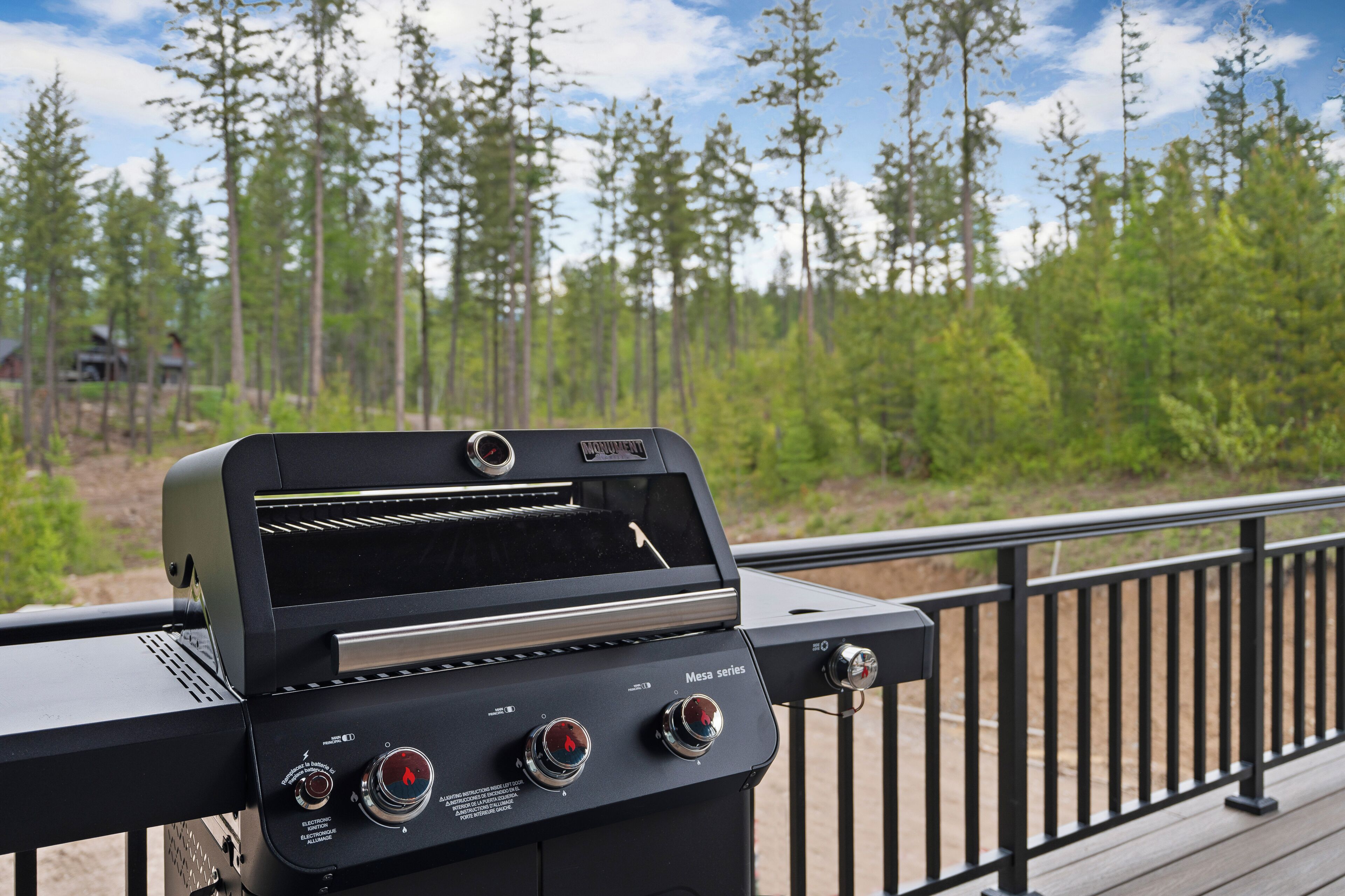 A barbecue grill with a digital display, control knobs, and a vent.