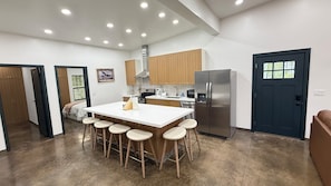 A modern kitchen with a central island, stainless steel appliances, and wooden cabinets.