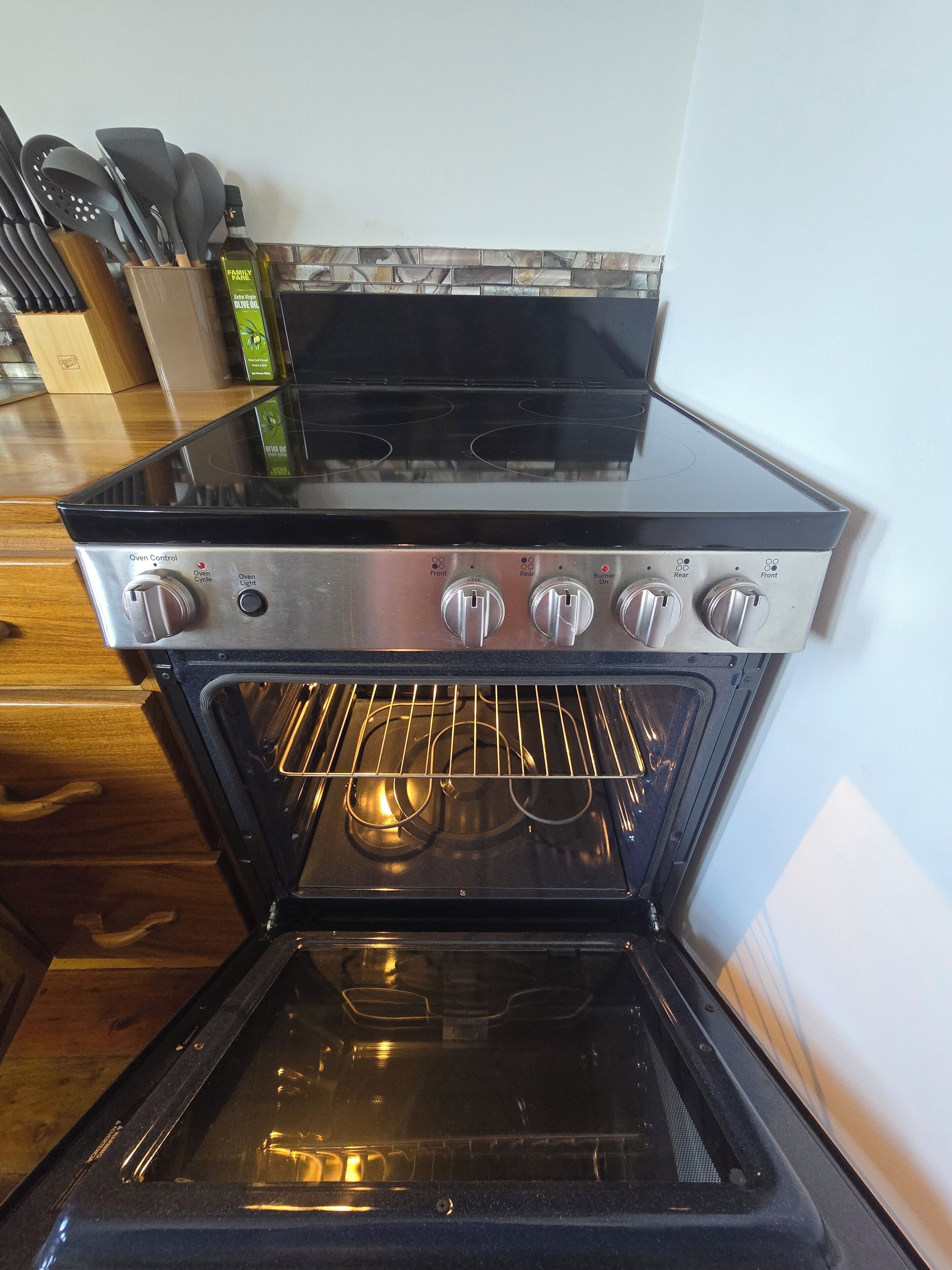 An oven with a control panel, a stovetop, and a glass door.