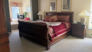 A bedroom with a large bed, two bedside tables, a nightstand, a window, and a door. - Magical Disney Retreat w/Private Heated Pool/Hot Tub - Spacious 5-bedroom (Kissimmee)