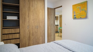 Ein Schlafzimmer mit einem großen Holzschrank, einem Bett mit weißer Daunendecke und einem Bild an der Wand.
