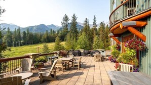 A patio with outdoor furniture, a barbecue grill, and a view of mountains. - Spectacular Ski-in/Ski-out Mountain Condo with A/C! (Fernie)