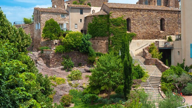 A stone building with a staircase leading to a door, surrounded by greenery. - 1 bedroom apt - Sea View & Pool, Roquebrune-Sur-Argens, France (Roquebrune-Sur-Argens)