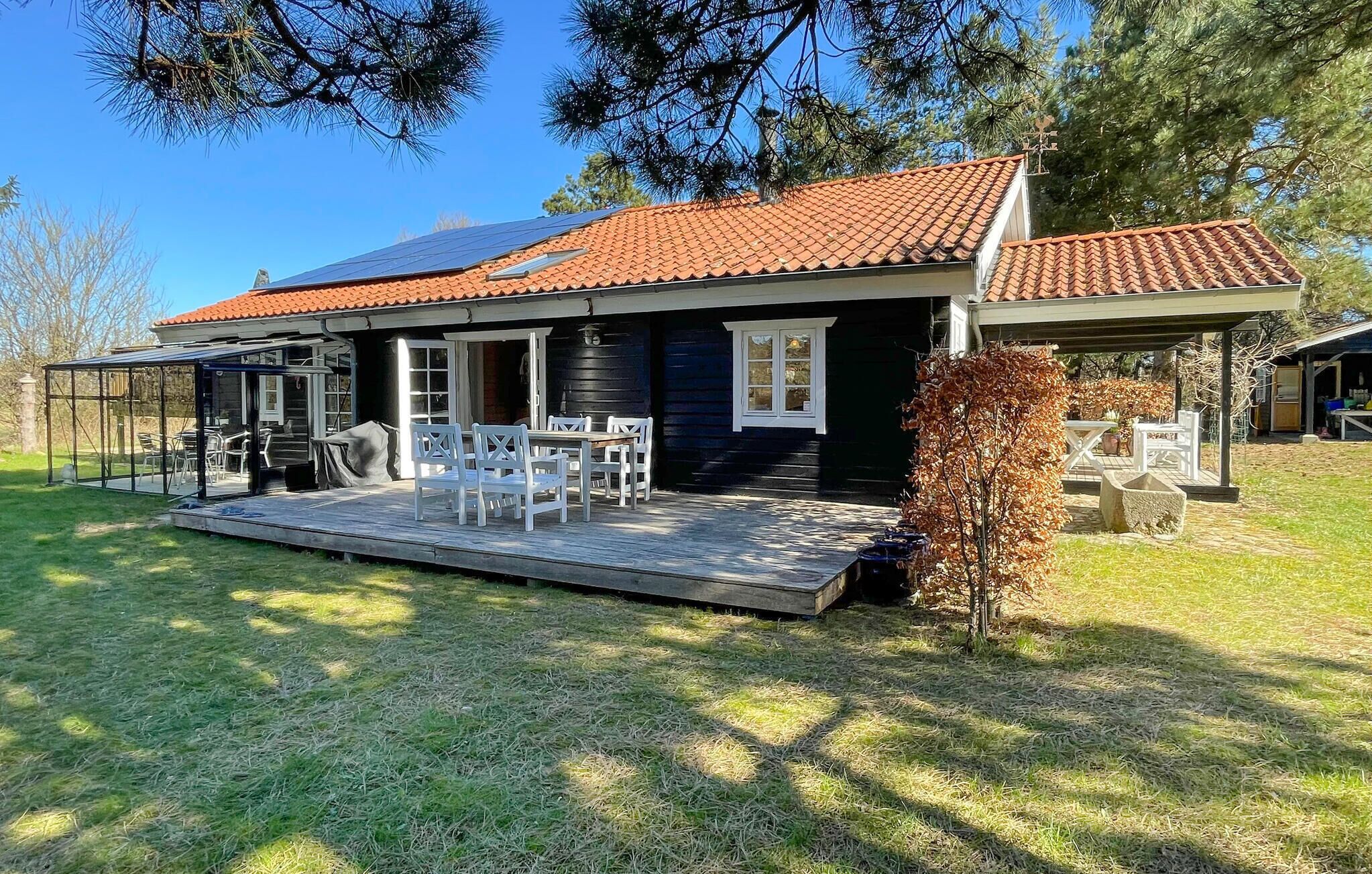 A house with a covered patio, outdoor seating, and a small garden.