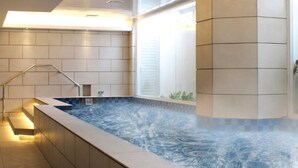 A modern indoor swimming pool with a clear view of the surrounding tiled walls and a staircase leading to an upper level. - Merakey Golf Residence  (Cikarang)