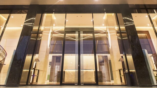 A modern building with a geometric glass ceiling, large windows, and a reflective floor. - Merakey Golf Residence  (Cikarang)