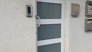 A door with a window, a mail slot, and two mailboxes on the wall. - Ground Floor Maisonette With Communal Pool in Qala (Qala)