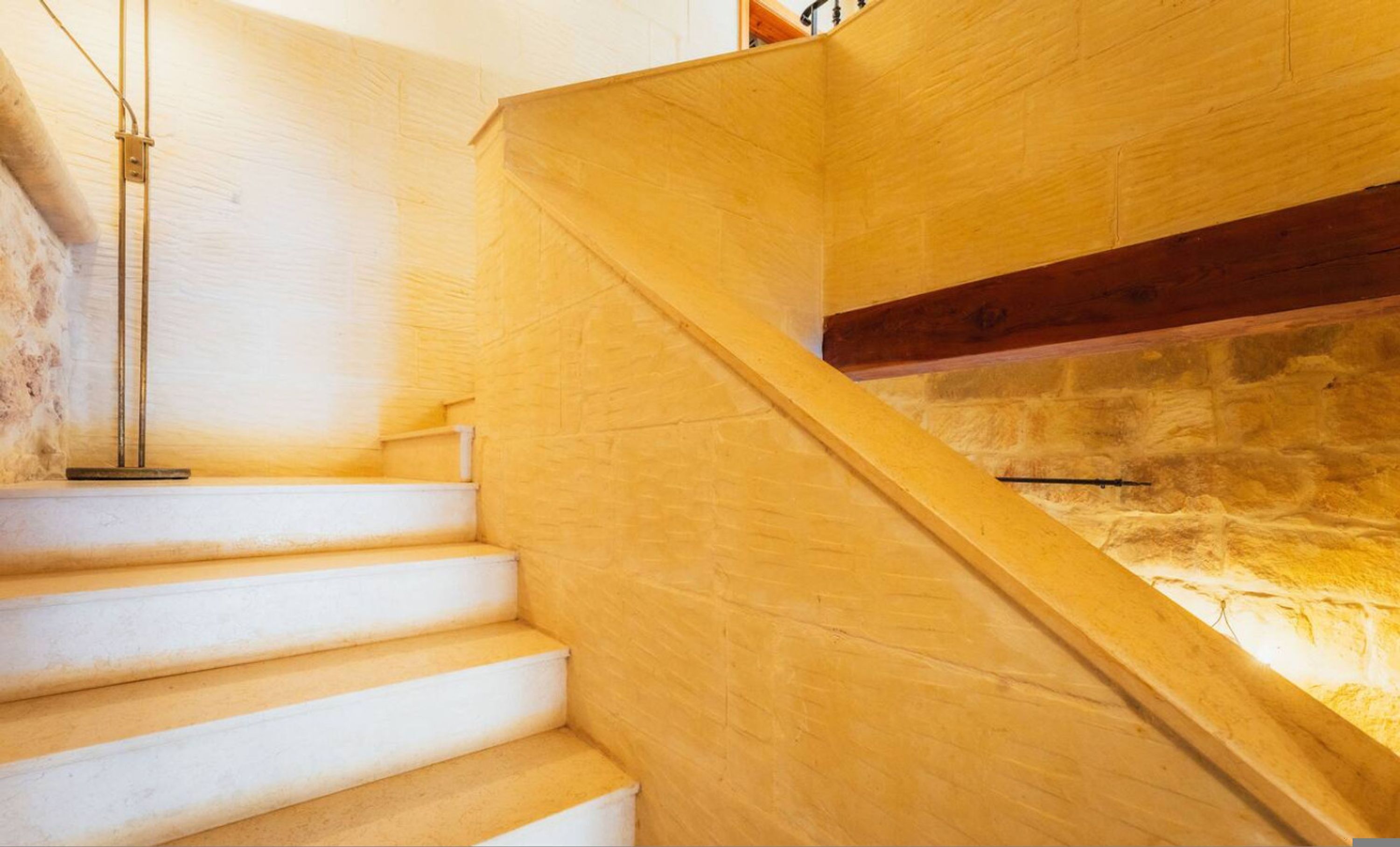 A wooden staircase with a stone wall background.