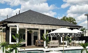 A modern house with a pool, outdoor seating, and a covered patio area. - Jungle Dream Oasis- Pool/Pickle Ball/ Game (Houston)