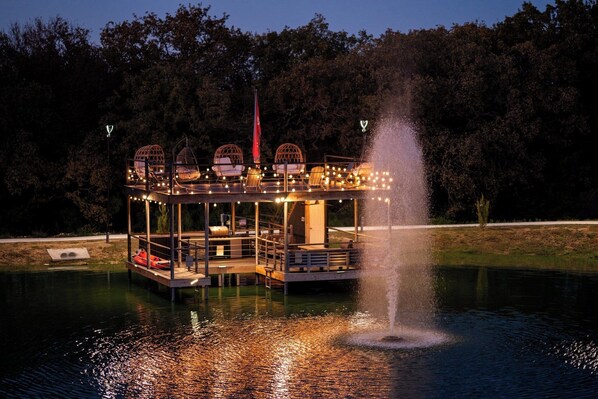 A water-based structure with seating, a fountain, and a flag.