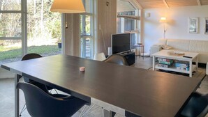 En moderne stue med spisebord, fjernsyn og sofa.