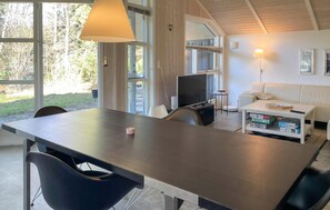 A modern living room with a dining table, a TV, and a sofa. - 2 bedroom stunning home in Vig (Vig)
