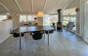 A modern interior with a dining table, chairs, a fireplace, and large windows. - 2 bedroom stunning home in Vig (Vig)