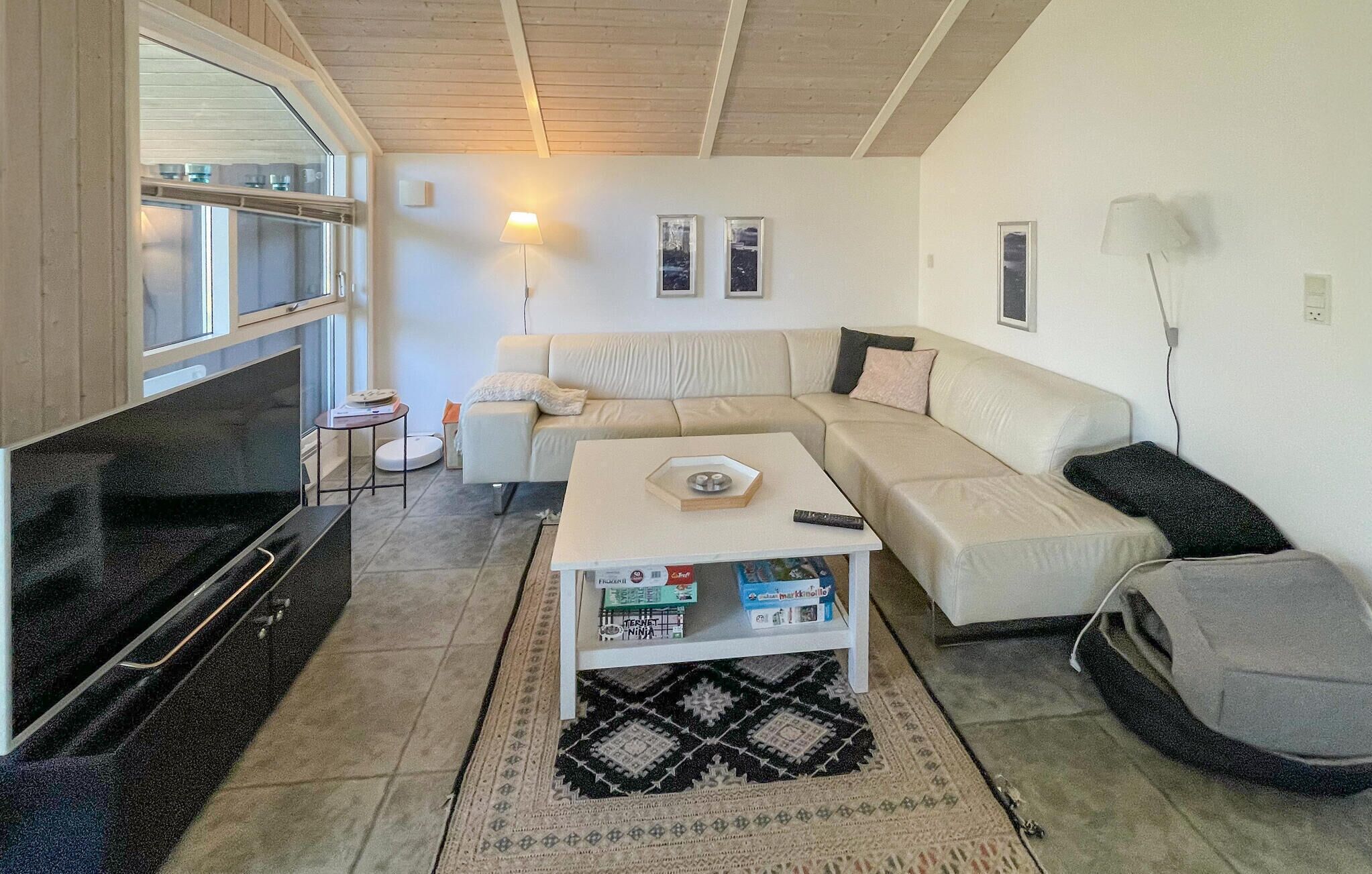 A living room with a sofa, coffee table, TV, and a small side table.