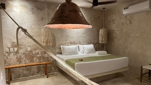 A bedroom with a bed, a hammock, a ceiling fan, and an air conditioning unit. - Hotel Boutique Alma Peregrina (Valladolid)