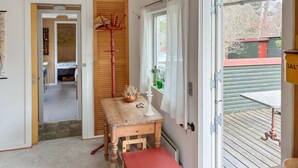 A room with a wooden table, a bench, a coat rack, and a window with curtains. - Awesome home in Kalundborg with WiFi (Kalundborg)