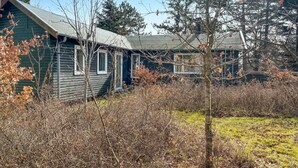 A rustic cabin with a sloped roof, surrounded by dense shrubbery and a small clearing. - Awesome home in Kalundborg with WiFi (Kalundborg)
