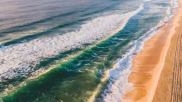 A beach with waves, a sandy shore, and distant hills. - Hawks Nest Hideaway | Spa, BBQ, Bikes & Pool Table (Hawks Nest)