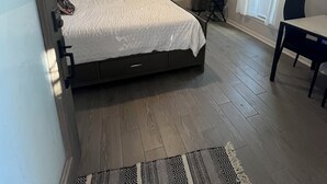 Camera da letto con un letto, una ventola a soffitto, una TV e una finestra con persiane.