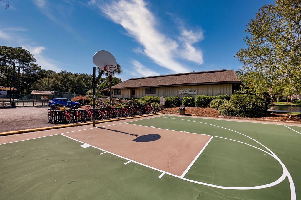 Ein Basketballplatz im Freien, im Hintergrund ein Gebäude mit der Aufschrift 'Island Club Tennis & Fitness Center'.