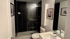 Ein modernes Badezimmer mit Dusche, Toilette und Waschbecken.