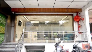 Ein Gebäudeeingang mit Glasfassade, einer Treppe und einem Motorrad davor.