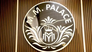 Ein rundes Schild mit der Aufschrift 'M.M. PALACE' und einem Wappen.