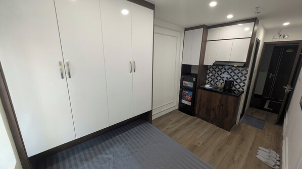 Una cocina moderna con armarios blancos, una encimera negra y un horno empotrado.