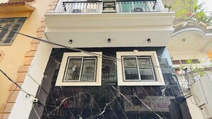 A multi-story building with a black marble facade, wooden shutters, and a sign indicating 'AIRA STAY.' - Aira Khuong Thuong Apartment (Hanoi)