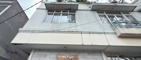 A building with a sign reading 'Wisma Angkrek Guesthouse & Rest.'