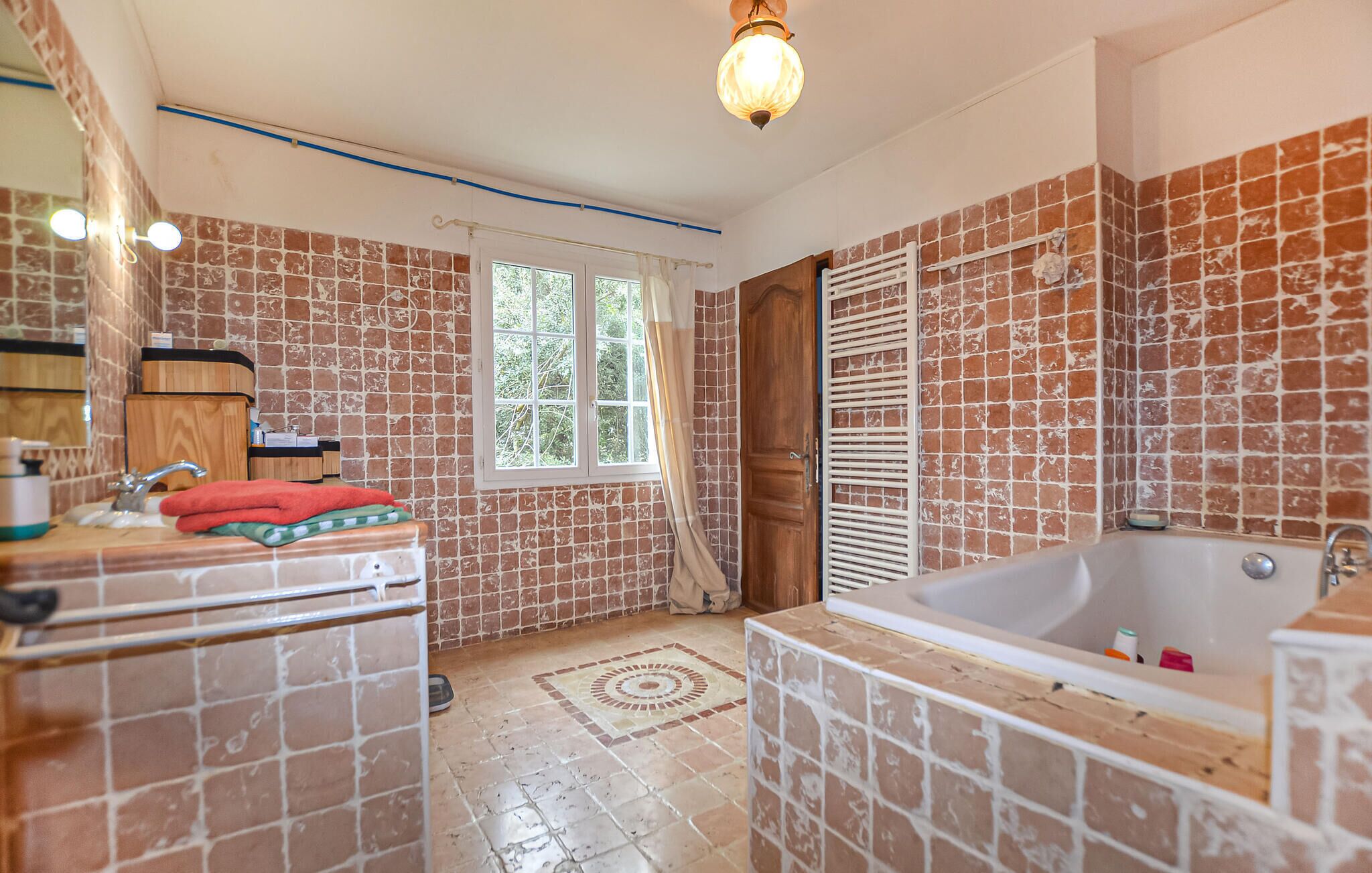 A bathroom with a bathtub, a sink, and a window.