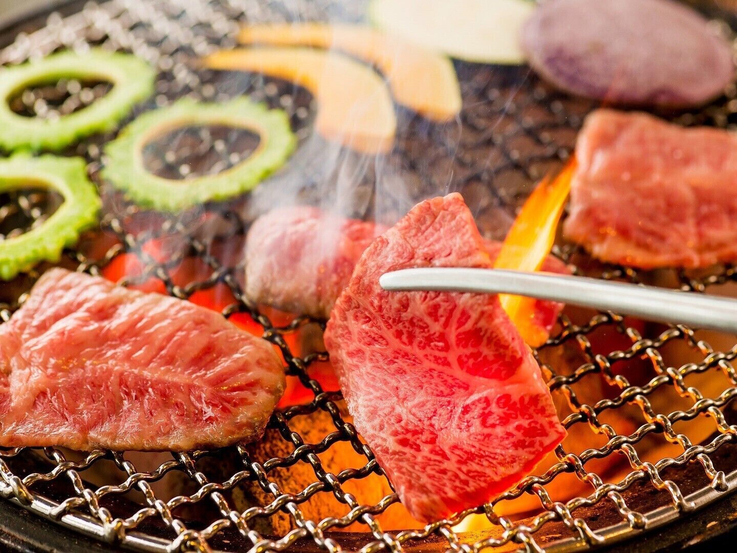 Una parrilla con diversos tipos de carne y verduras.