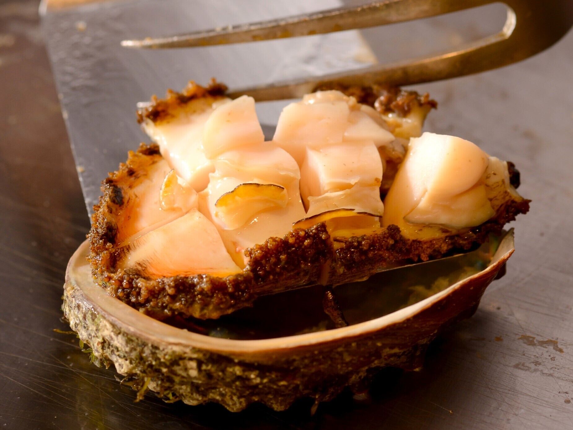 A clam with a piece of bread and butter on top.