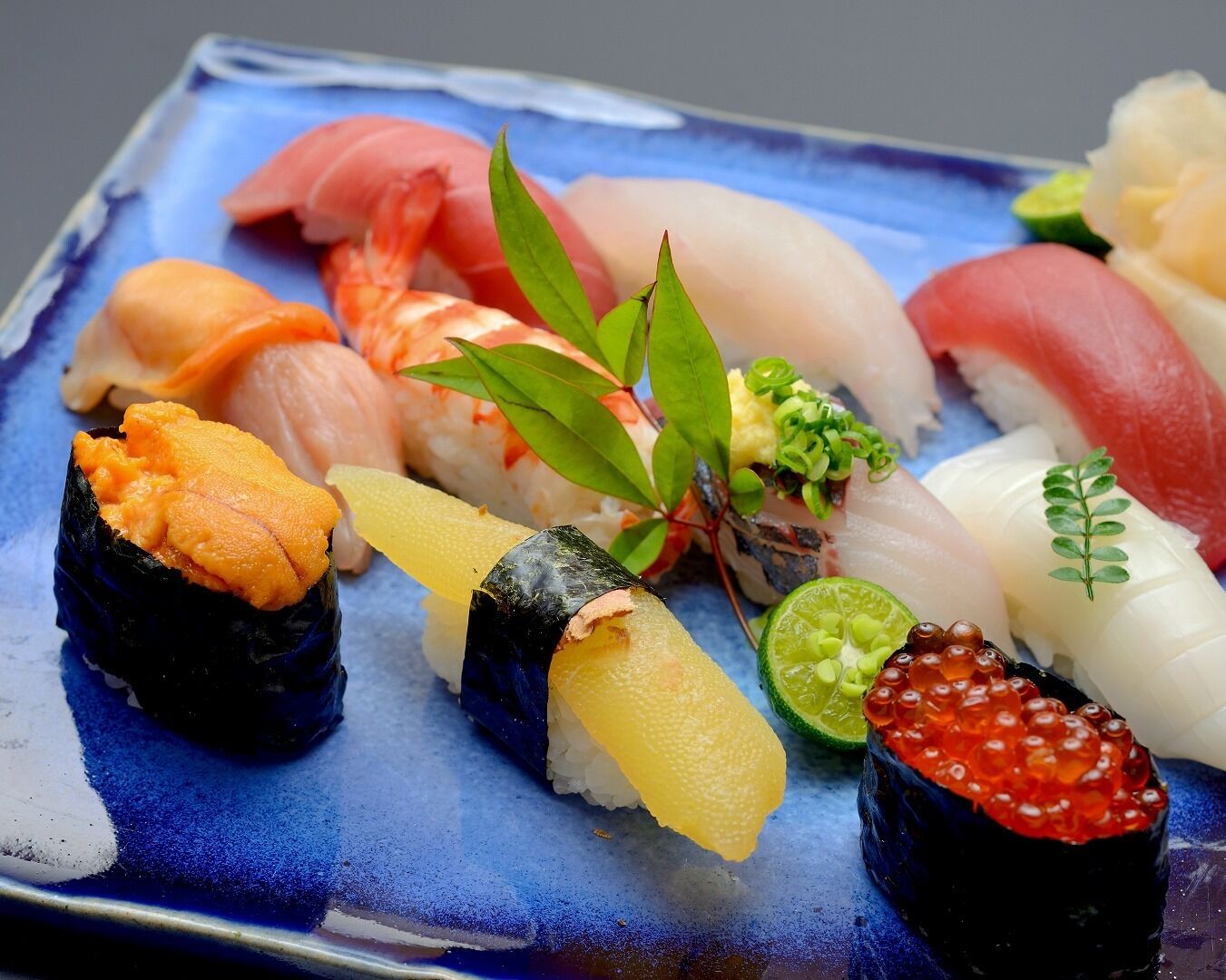 A variety of sushi on a blue plate.