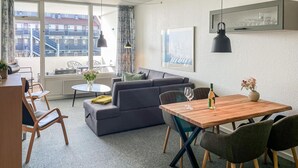 Un salon moderne avec un canapé gris, une table à manger en bois et des chaises.